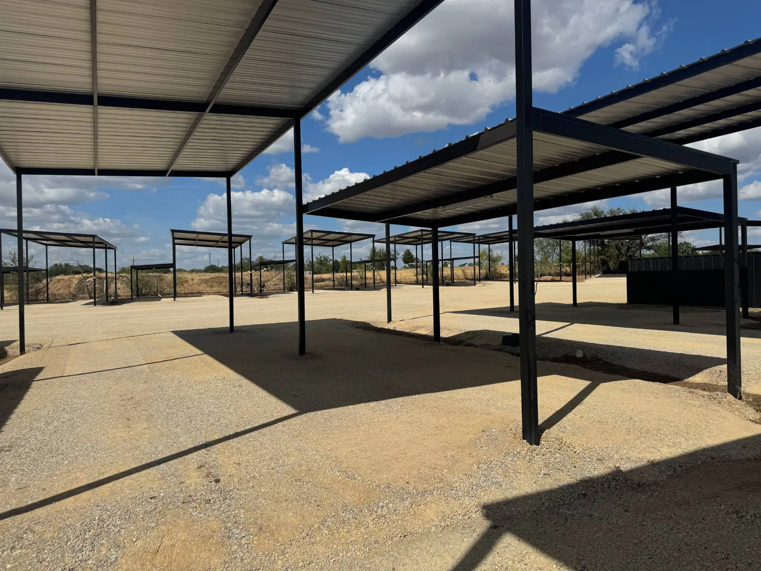 Covered sites in a row, with the gravel drive between them